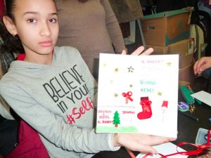 une jeune fille tient une carte de noel